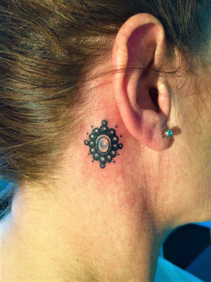 ladies' ear tattoo with gemstone is cool.