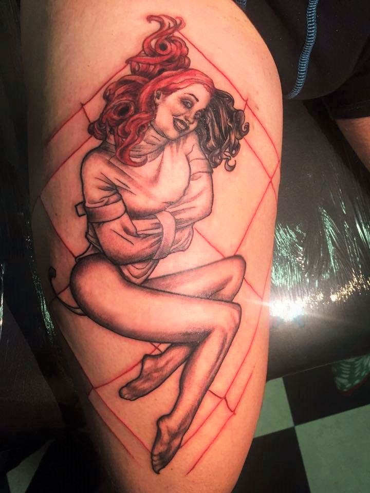Realistic pinup in a straight jacket-tattoo.