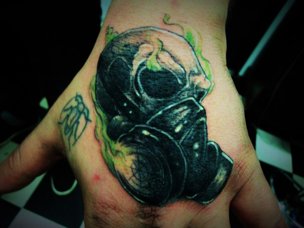 Realistic gasmask skull tattoo hand.