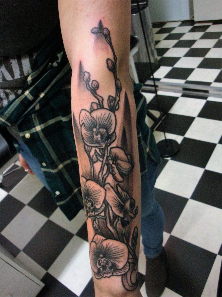 custom black and grey arm-orchids sleeve tattoo from our rotterdam inkshop.