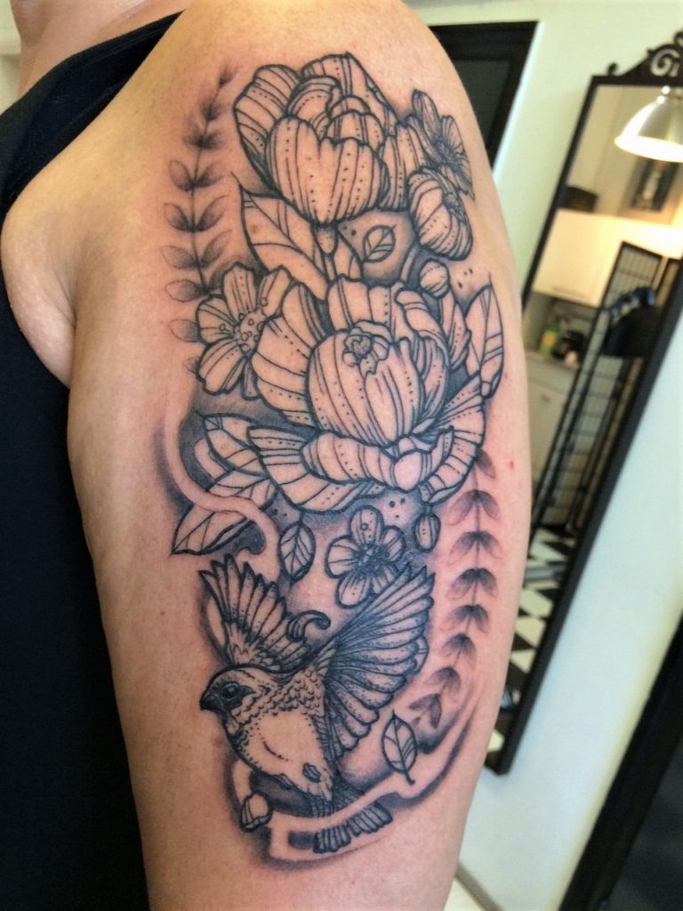 armtattoo of peony flowers and a bird.